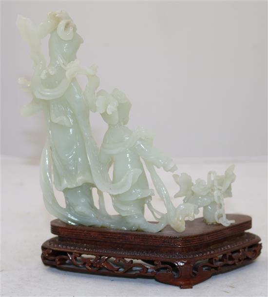 A Chinese pale celadon jade group of a lady and a girl with flowing robes, a basket beside them, 20th century, total height 19cm